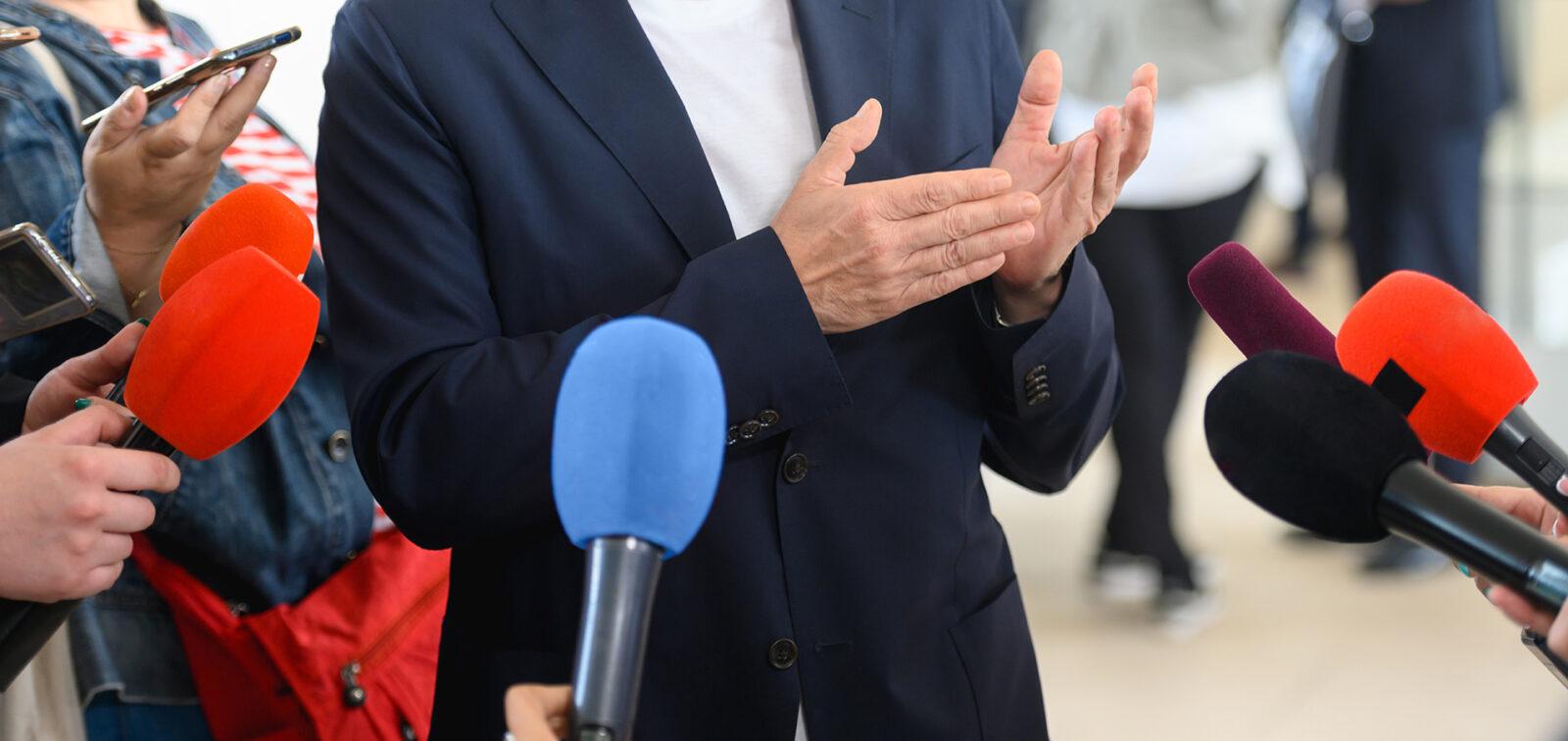 Vip person surrounded by journalists at a press conference