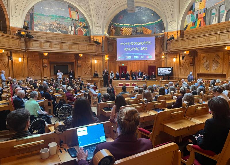 Funktionsrättsriksdagen 22 april 2026 i Förstakammarsalen, Sveriges Riksdag. Foto: HRF Översikt över fullsatt sal med powerpointbild där det står "Funktionsrättsriksdagen".